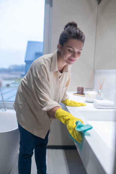 A young woman in yellow gloves cleaning the surfaces in the bathroom Disinfecting the bathroom. A young woman in yellow gloves cleaning the surfaces in the bathroom surface disinfection stock pictures, royalty-free photos & images