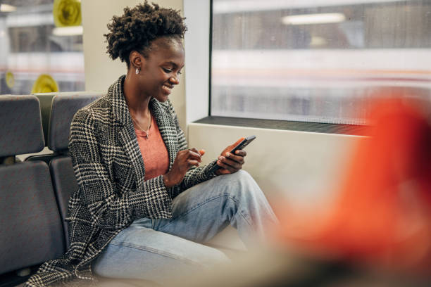 istock Young black woman suing smartphone in the train 1394407065
