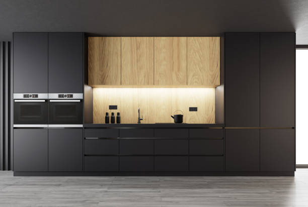Matte black kitchen with natural oak wood on one wall stock photo