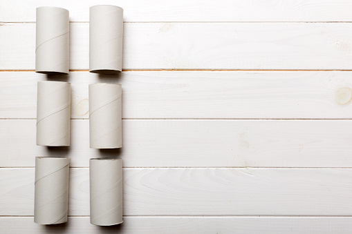 Flat lay composition with empty toilet paper rolls and space for text on color background. Recyclable paper tube with metal plug end made of kraft paper or cardboard.