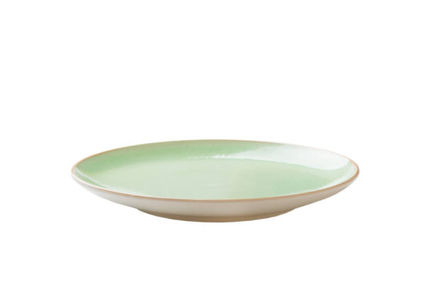 Green ceramic round plate isolated over white background. perspective view