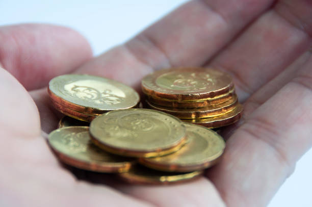 istock Hand showing gold coins with white background. Finance or saving concept 1394410952
