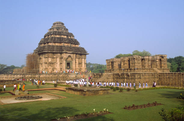 Tourists at the Konark Sun Temple ancient Hindu Temple Odisha India Konark Sun Temple, Odisha, India: Local tourists at the ancient Surya Hindu Temple. 13th Century AD. A masterpiece of Odishan temple architecture and a World heritage site. chariot wheel at konark sun temple india stock pictures, royalty-free photos & images