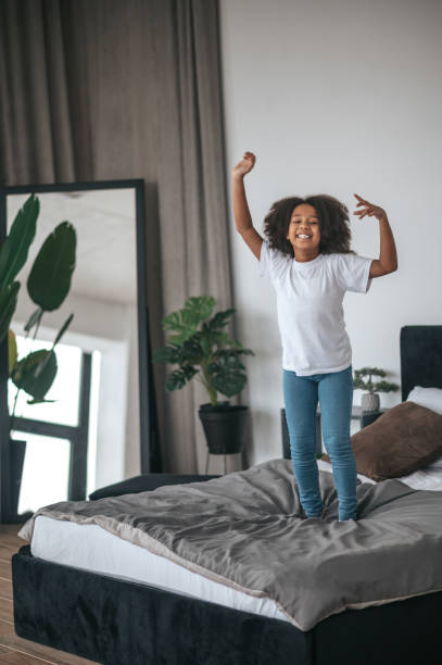 istock A cute curly-haired girl having fun and looking enjoyed 1394411296