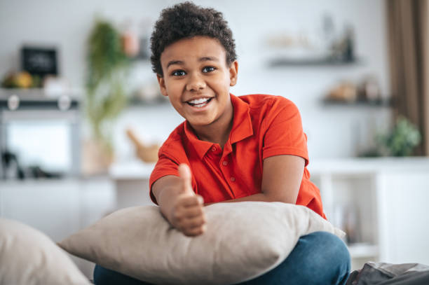 istock A boy in orange tshirt stretching his hand and looking excited 1394411347