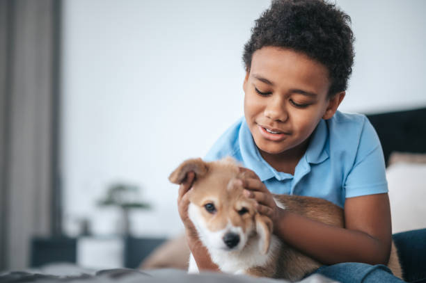 istock A dark-skinned boy holding a cute puppy and smiling 1394411400