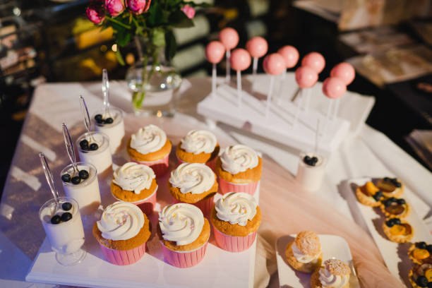 istock Candy bar with cupcakes and cake pops and different desserts at restaurant reception. 1394415004