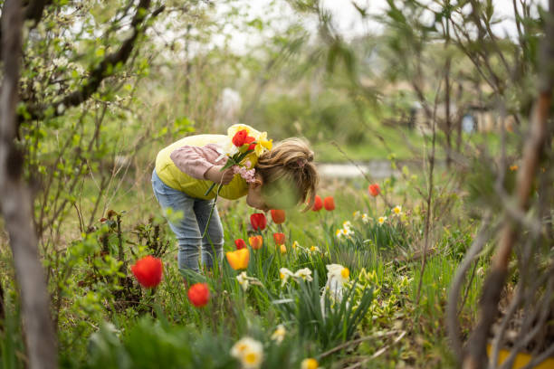 istock Little girl smelling flowers 1394420077