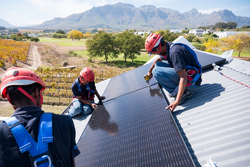 Trabajadores calificados conectan e instalan paneles solares photo