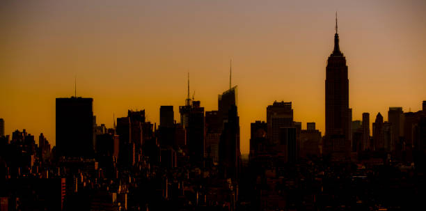 istock Midtown Manhattan silhouetted against an orange glowing sky 1394421085
