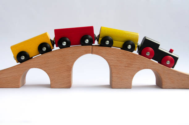 Wooden toy train crossing track bridge. Copy space concept