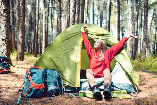 Female With Blond Hair Waking Up And Watching The Sky During Camping Trip