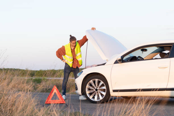 istock Angry man checking his broken car engine to fix it for going back home after a long trip day 1394425980
