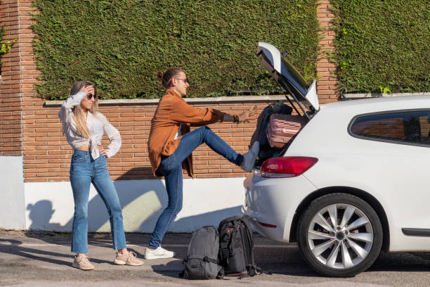 Desperate young couple trying to get all the suitcases in the car to go on a road trip for spring break Desperate young couple trying to get all the suitcases in the car to go on a road trip for spring break. Vehicle packed concept trunk stock pictures, royalty-free photos & images