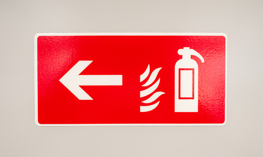 A bright red sign on an internal wall, indicating where a fire extinguisher can be found.