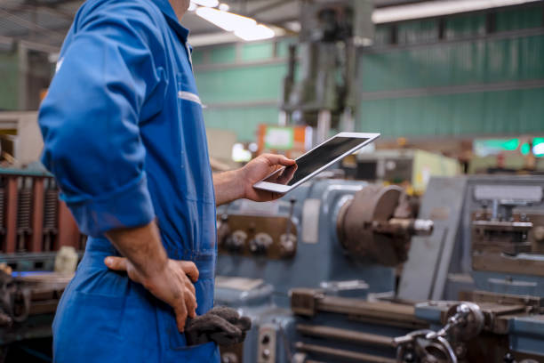 istock Blue collar worker with co worker at factory. 1394431474