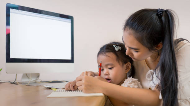 istock Young Asian beautiful mom with her daugther kid work at home. 1394435249