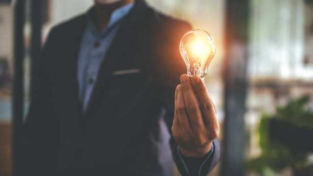 mano sosteniendo una bombilla. concepto innovador con inspiración y concepto de ahorro energético. - inventor fotografías e imágenes de stock