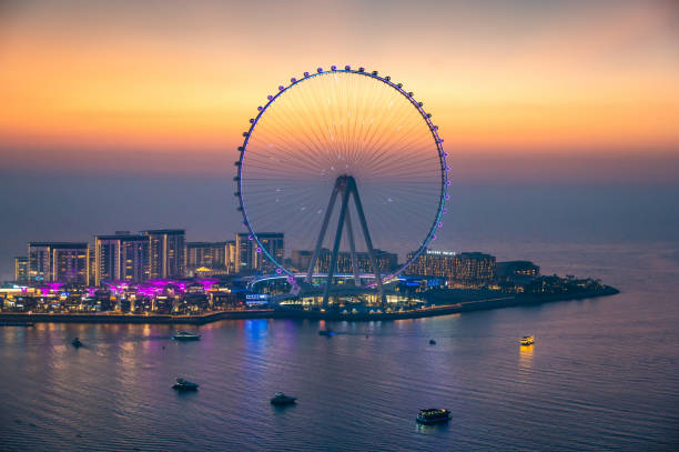 Bluewaters island in Dubai with large Ferris wheel seen from JBR beach in marina area Bluewaters island in Dubai with Ain Dubai Ferris wheel seen from JBR beach in marina area at sunset dubai island stock pictures, royalty-free photos & images