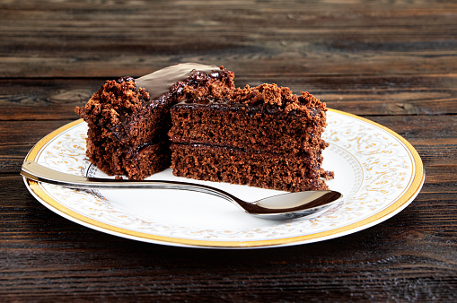 A piece of Chocolate cake on a plate on a wooden background.Slice of Homemade brownie cake.Copy space.