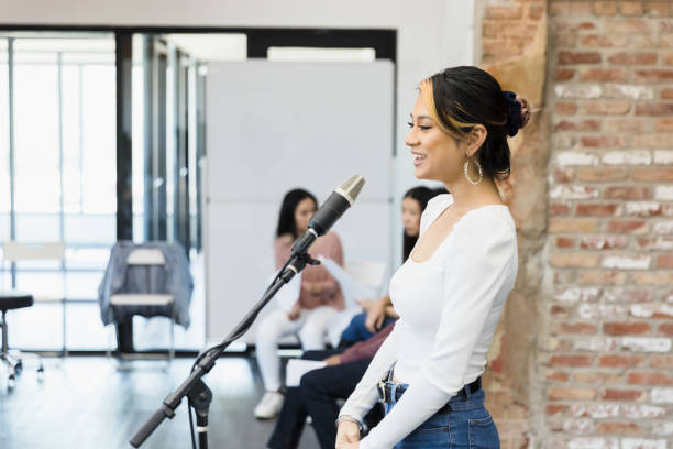 istock Profile view young female actress reciting lines into microphone 1394454628