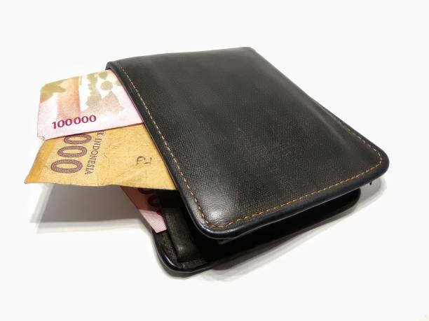 istock Money in black leather wallet isolated on white background 1394454816