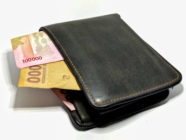 istock Money in black leather wallet isolated on white background 1394454829
