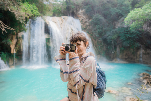 Young Caucasian woman photographing near El Chiflon waterfall in Chiapas, Mexico