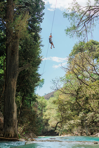Young man  on zip-line above  El Chiflon waterfall in Chiapas, Mexico