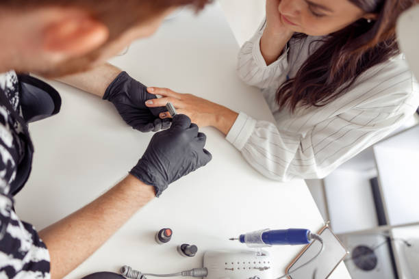 istock Manicure specialist doing nail care for client in studio 1394459354