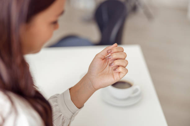 istock Female client enjoying groomed hands in nail salon 1394459361