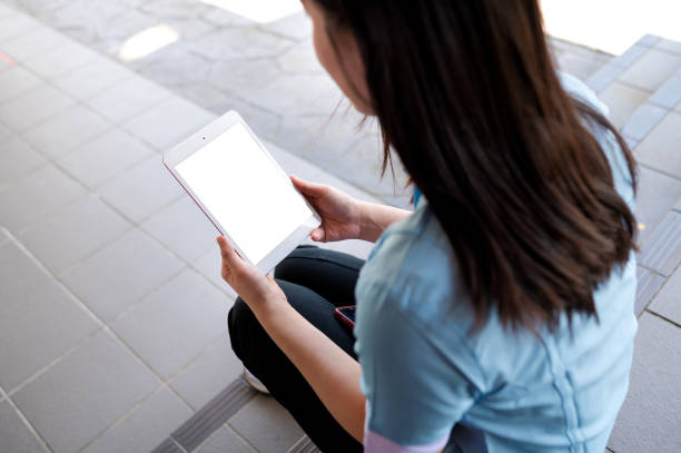 istock Asian female medical worker in scrubs using digital tablet 1394460818