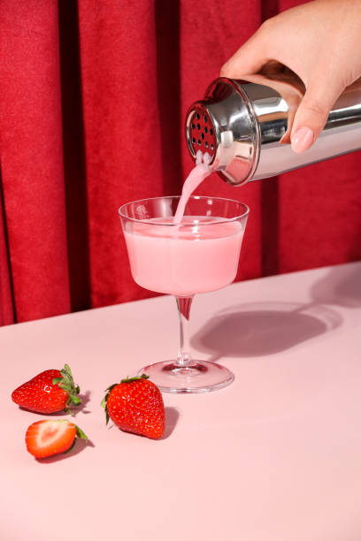 Pink drink strawberry cocktail pouring in retro style bar with velvet curtain Pink drink strawberry cocktail pouring in retro style bar with velvet curtain food styling stock pictures, royalty-free photos & images