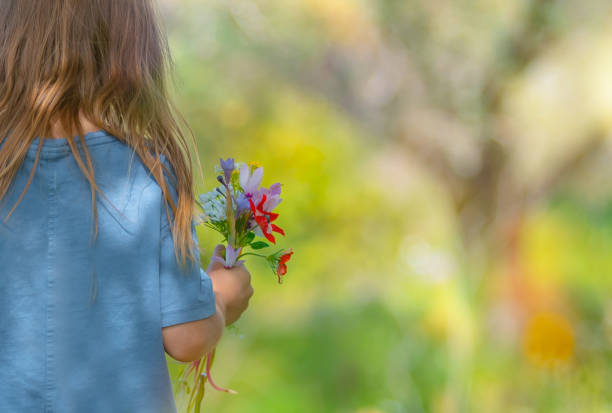 A purple flower in the hands of a child