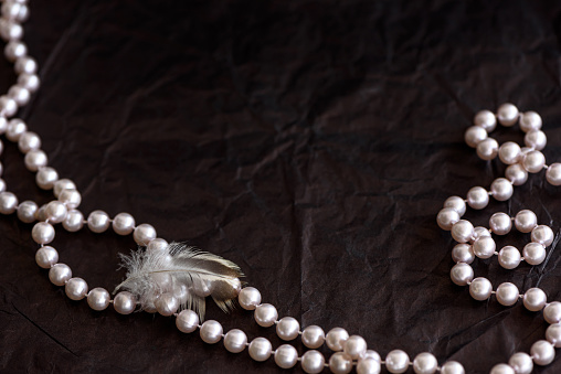 Pearl luxury necklace with precious stones in white golden frame on neck stand display in mannequin, close up