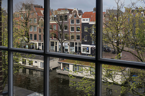 view out of a window of a house along the Prinsengracht canal in the historic district of the city center of Amsterdam