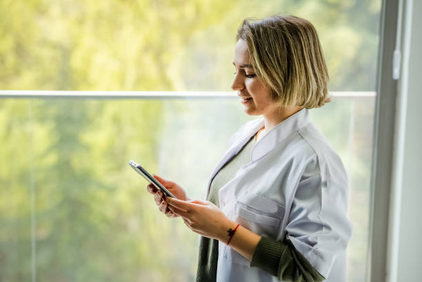 Female Healthcare Worker using mobile phone at the clinic. stock photo