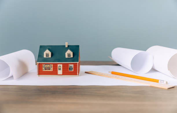 istock small toy house on architectural blueprints. 1394480718