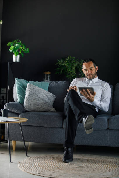 istock Businessman relaxing on the sofa and using digital tablet 1394481593