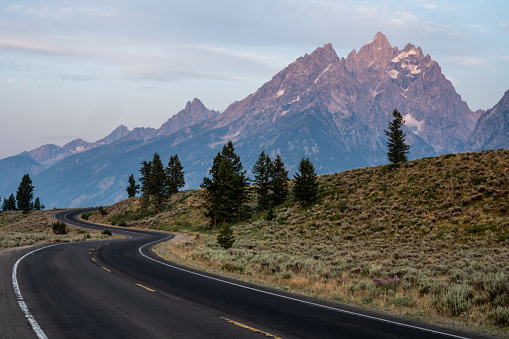 Winding Road Climbs Hillside in front of the Teton Range