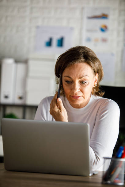 istock Charming mature businesswoman on a conference call using laptop 1394483871
