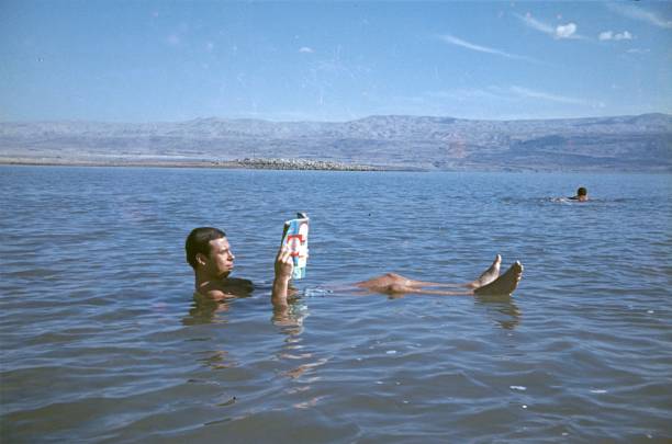 Dead Sea, Israel, 1975. A man reads a magazine while swimming in the Dead Sea.