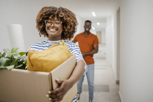 istock Couple carrying boxes into new home on moving day 1394487919