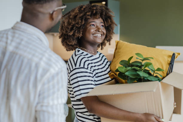 istock Couple carrying boxes into new home on moving day 1394487940