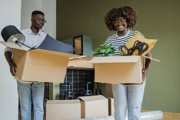 istock Couple carrying boxes into new home on moving day 1394488043