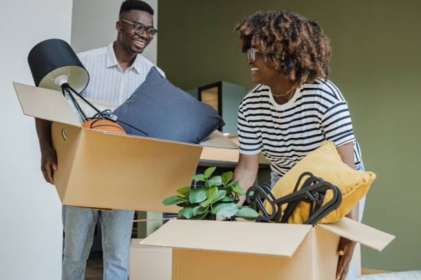 istock Couple carrying boxes into new home on moving day 1394488052