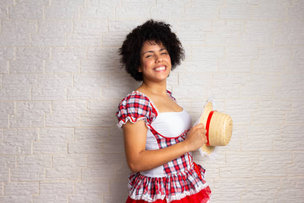 girl with curly hair wearing traditional junina costume holding hat with big smile Confident african american girl with curly hair wearing traditional junina costume holding hat with big smile. Brazilian June Party, typical celebration in Brazil. 21 24 months stock pictures, royalty-free photos & images