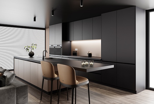 Luxury apartment with living room interior and modern minimalist kitchen with big kitchen island and stools.
Black matte cabinets with dark gold details. Black carpet. Grey sofa. Hardwood floor.  Italian style interior design. 3d rendering