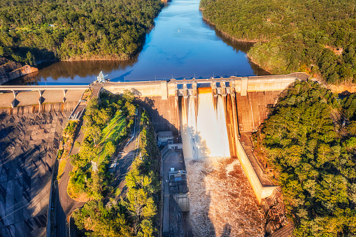 Spilling over the Warragamba dam leaking water in Blue Mountains of Australia during floods - aerial view.