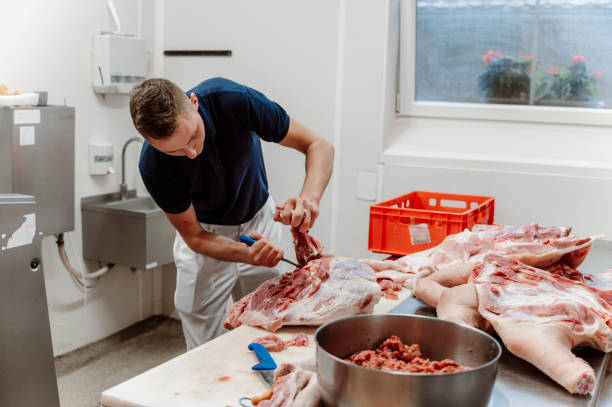 istock Young butcher cutting pieces of meat 1394500523